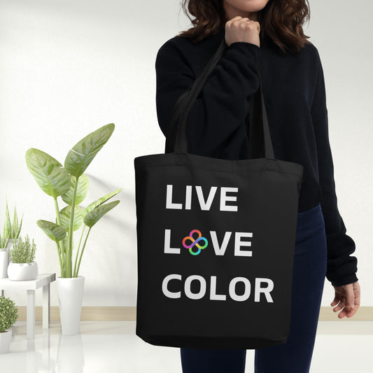Black canvas tote bag with white bold print that says LIVE LOVE COLOR. The letter O in the word LOVE has been replaced with rainbow infinity symbols.