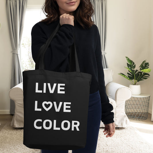 Black canvas tote bag with white bold print that says LIVE LOVE COLOR. The letter O in the word LOVE has been replaced with a heart symbol.