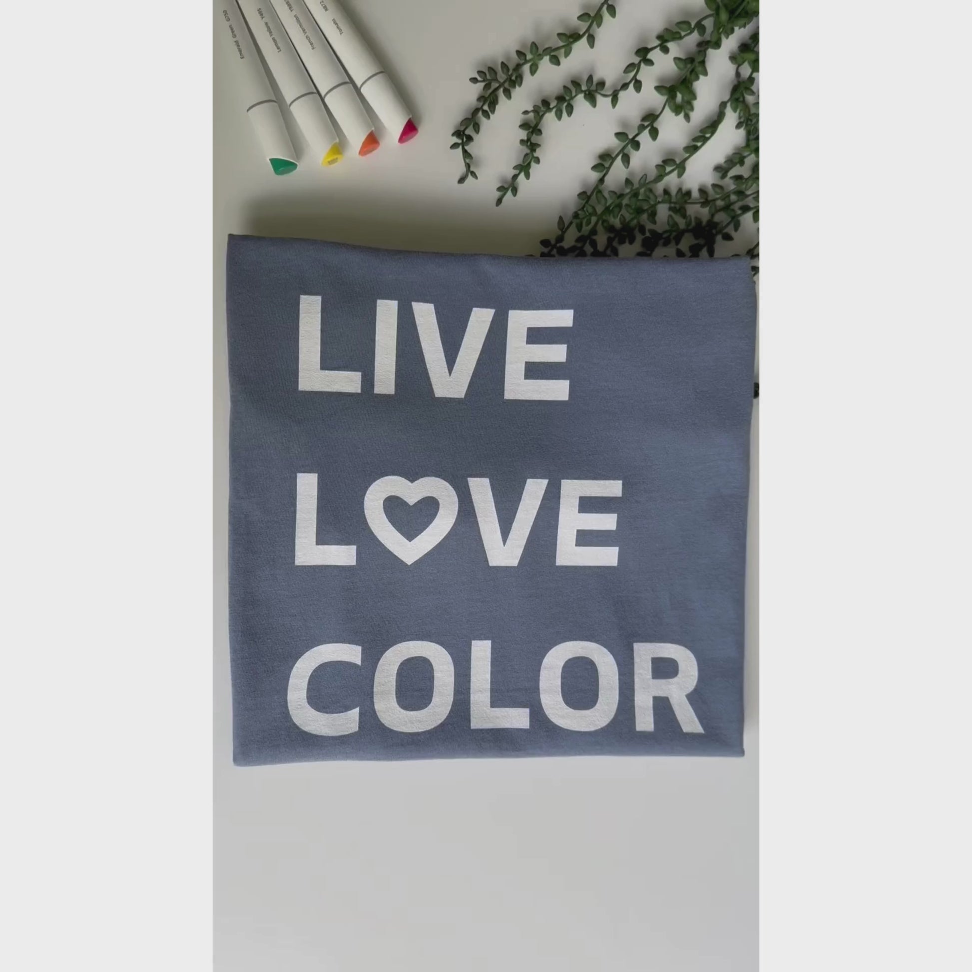 Blue Jean color T-Shirt with white bold print that says LIVE LOVE COLOR. The letter O in the word LOVE has been replaced with a heart symbol.