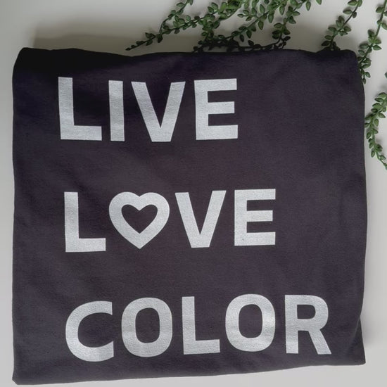 Black color T-Shirt with white bold print that says LIVE LOVE COLOR. The letter O in the word LOVE has been replaced with a heart symbol.