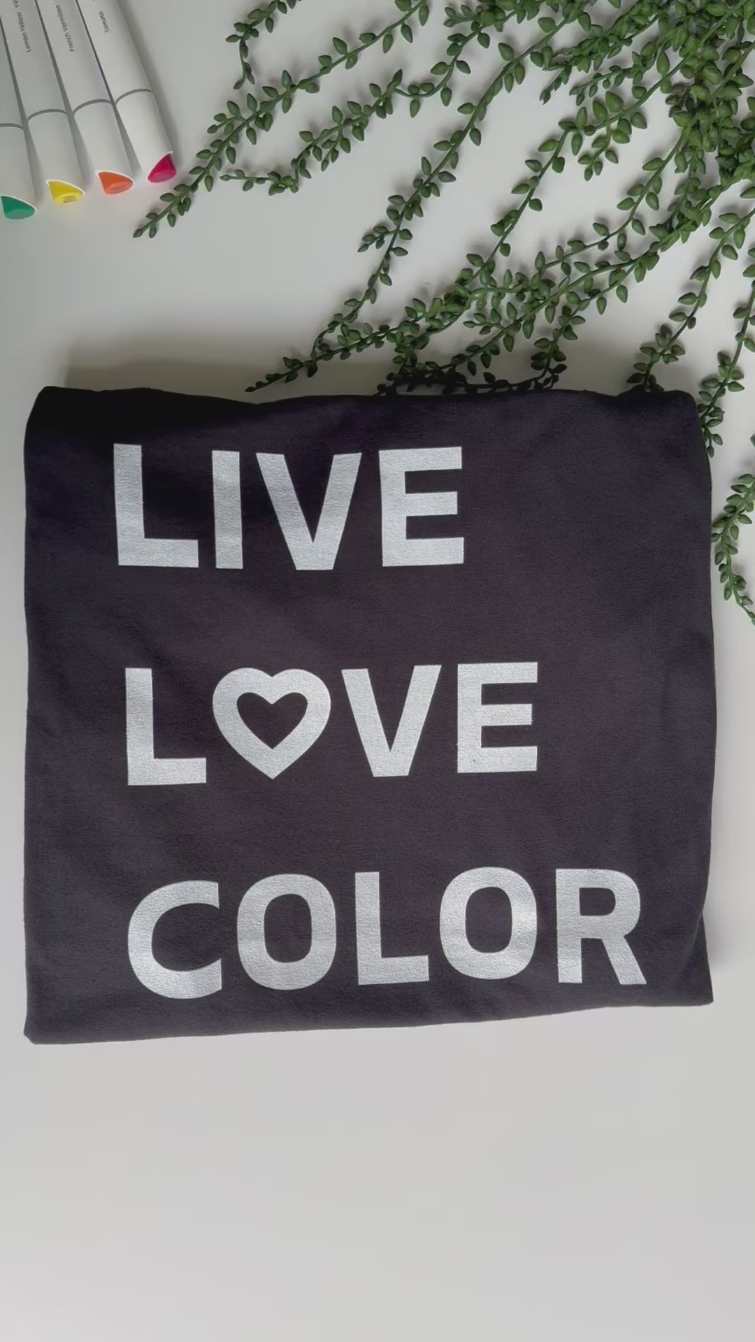 Black color T-Shirt with white bold print that says LIVE LOVE COLOR. The letter O in the word LOVE has been replaced with a heart symbol.